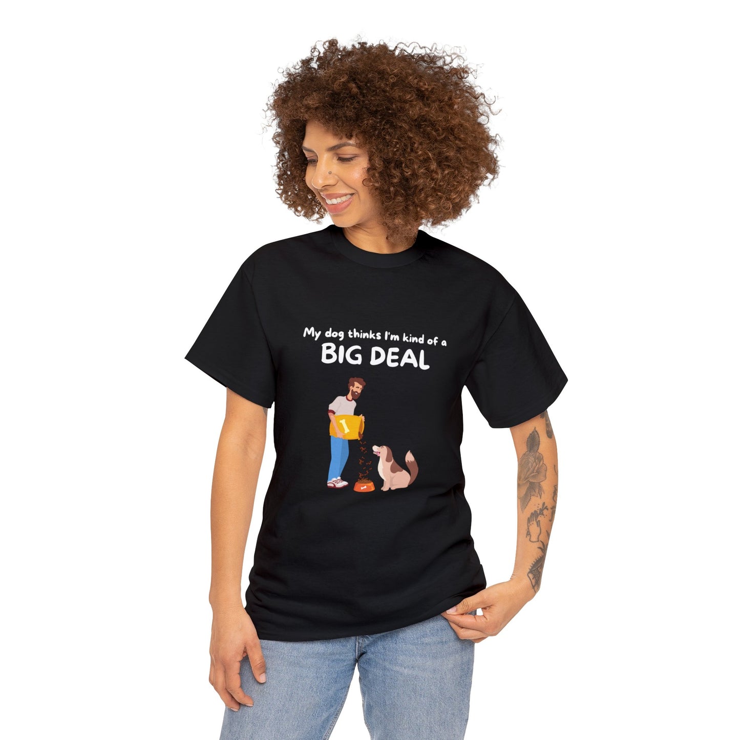 Person wearing the Unisex Heavy Cotton Tee - MY DOG THINKS IM A BIG DEAL, a black T-shirt with a seamless design featuring a cartoon of a person and dog. The text reads, "My dog thinks I'm kind of a big deal." Perfect for any dog lover looking to make an eco-friendly statement in sustainable style.