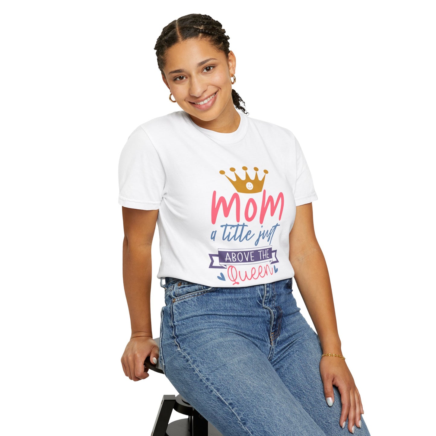 A person sitting on a stool dons the Unisex Comfort Colors 1717 Garment-Dyed T-Shirt, featuring the phrase "mom just a little above queen," highlighting the soft comfort of its ring-spun cotton fabric.