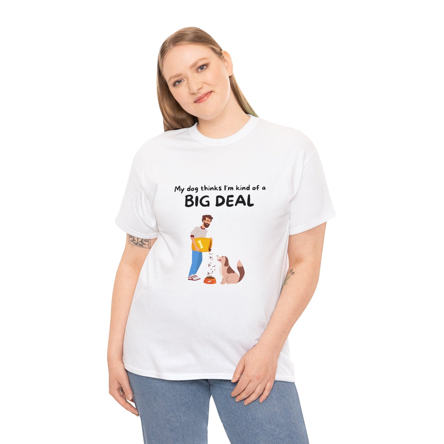 A dog lover proudly sports the Unisex Heavy Cotton Tee in white, which features a sustainable design with the text "My dog thinks I'm kind of a big deal" along with an elegant illustration of a person and their canine companion.