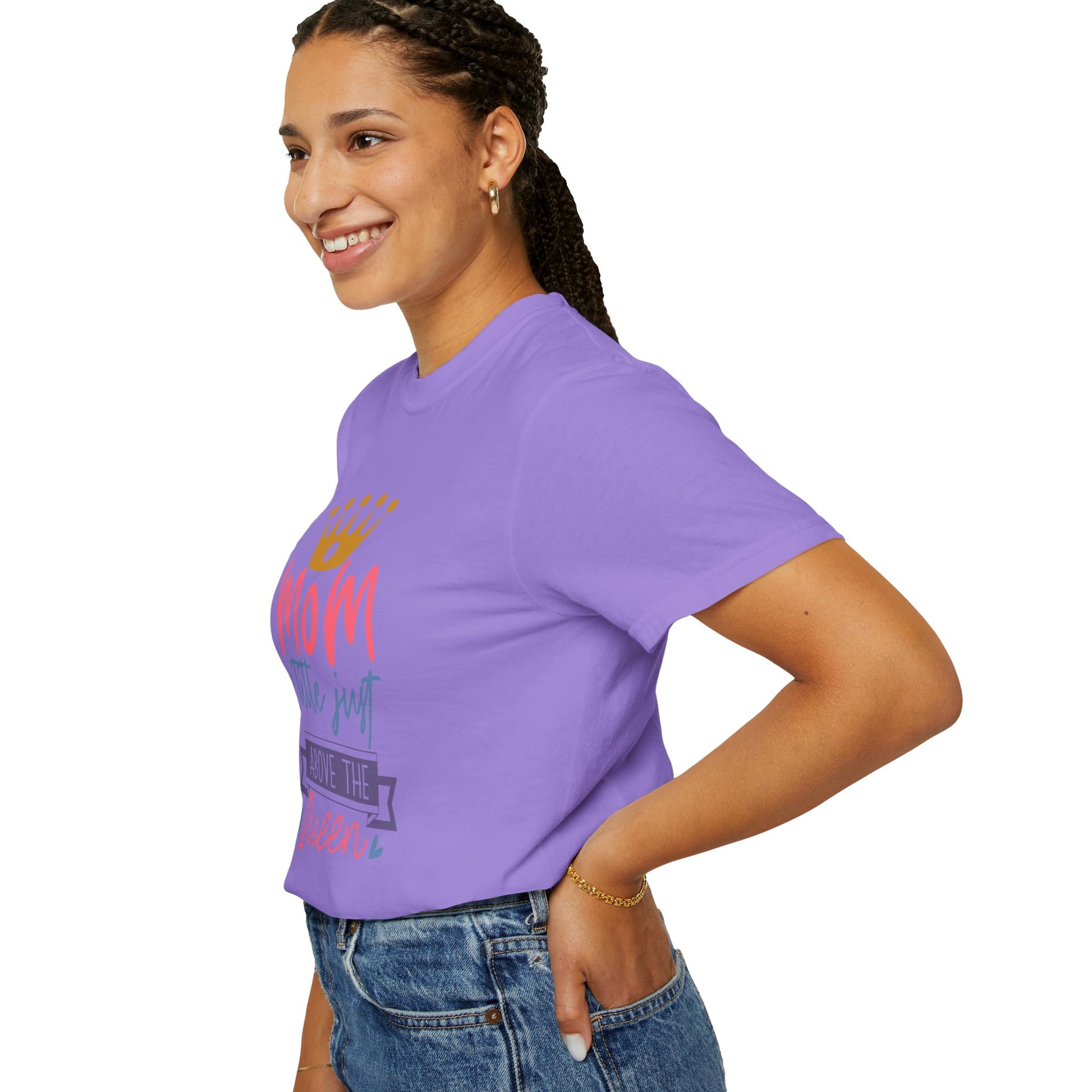 A person wearing a purple Stylish Comfort with Unisex Comfort Colors 1717 Garment-Dyed T-Shirt featuring the "mom just a little above queen" graphic stands in a side profile, smiling.