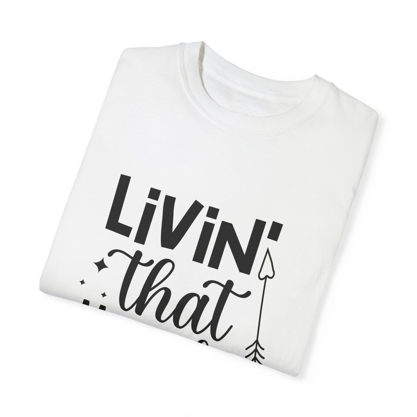 This folded white Unisex Comfort Colors 1717 Garment-Dyed T-Shirt showcases the phrase "Living that Mom Life" in bold black letters, complemented by an arrow design below. Made from ultra-soft ring-spun cotton, it effortlessly blends style and comfort.