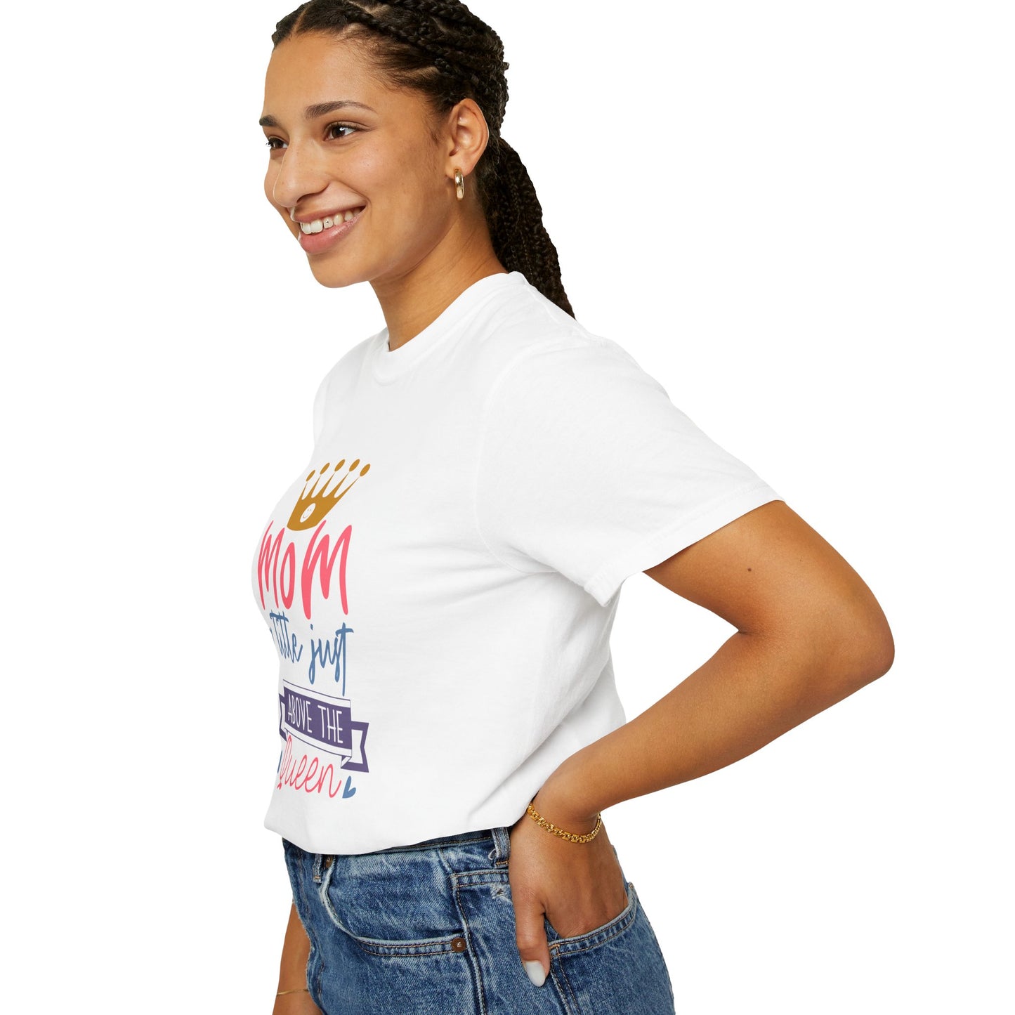 A woman wearing a Stylish Comfort unisex Comfort Colors 1717 garment-dyed t-shirt, featuring colorful text that reads "mom just a little above queen," made from soft ring-spun cotton, stands with her hand on her hip, smiling.