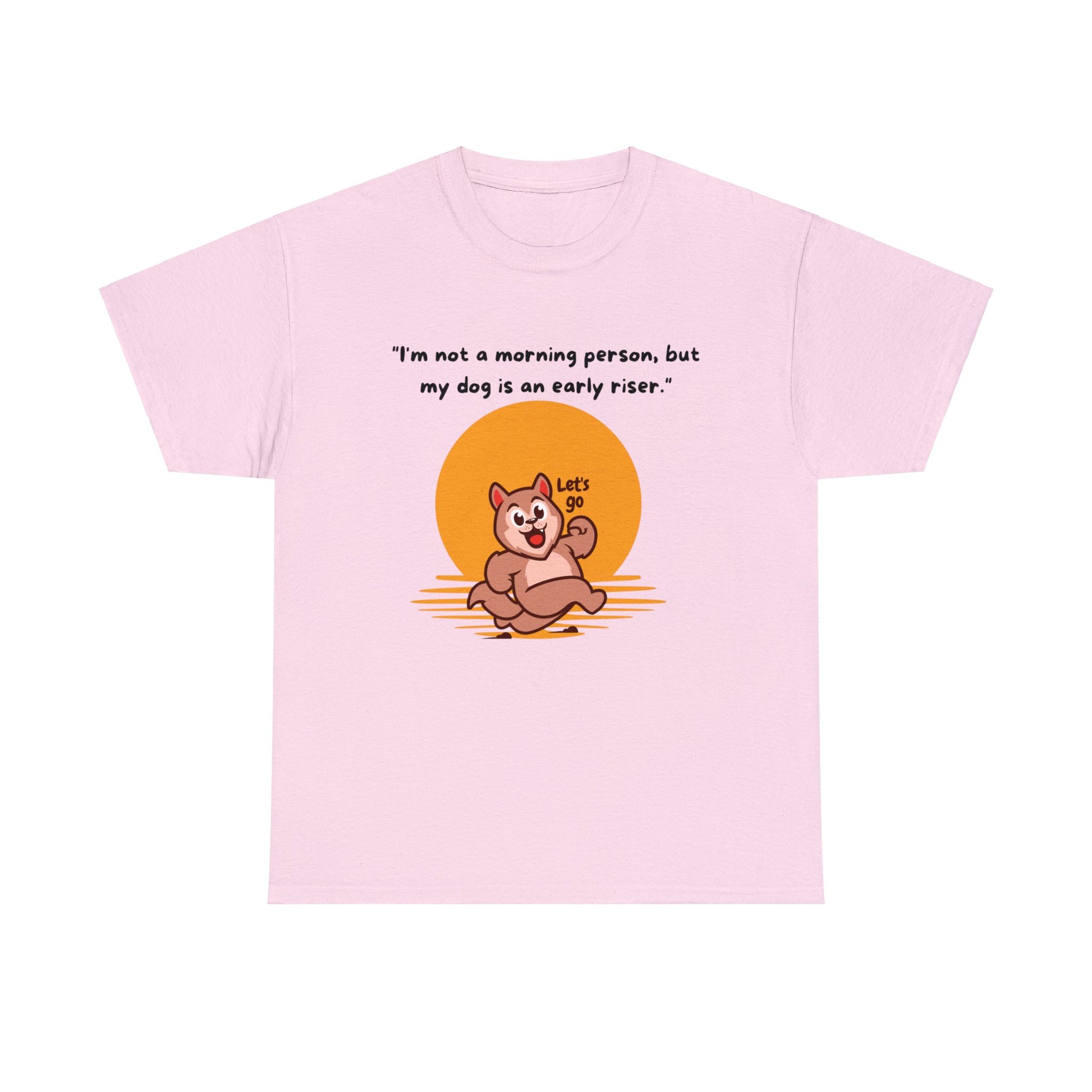 This Unisex Heavy Cotton Tee, crafted from 100% cotton in pink, showcases a cartoon dog set against a sunrise backdrop along with the humorous text: "I'm Not A Morning Person; But My Dog Is An Early Riser." Appreciate the classic fit while celebrating your sustainable style.