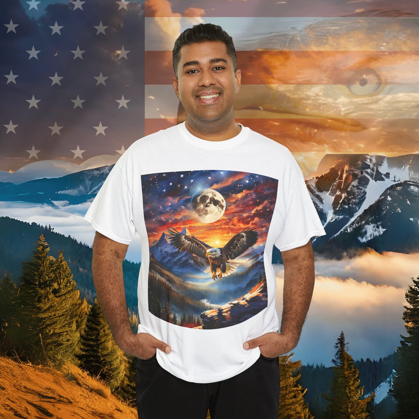 A person smiles, wearing a Unisex Heavy Cotton Tee - Stars, Stripes, and Soaring Spirit: A Bald Eagle's Tribute made from sustainably sourced cotton, featuring a nature scene with an eagle in flight. The background has an American flag overlay with a mountainous landscape and an eagle's face visible.