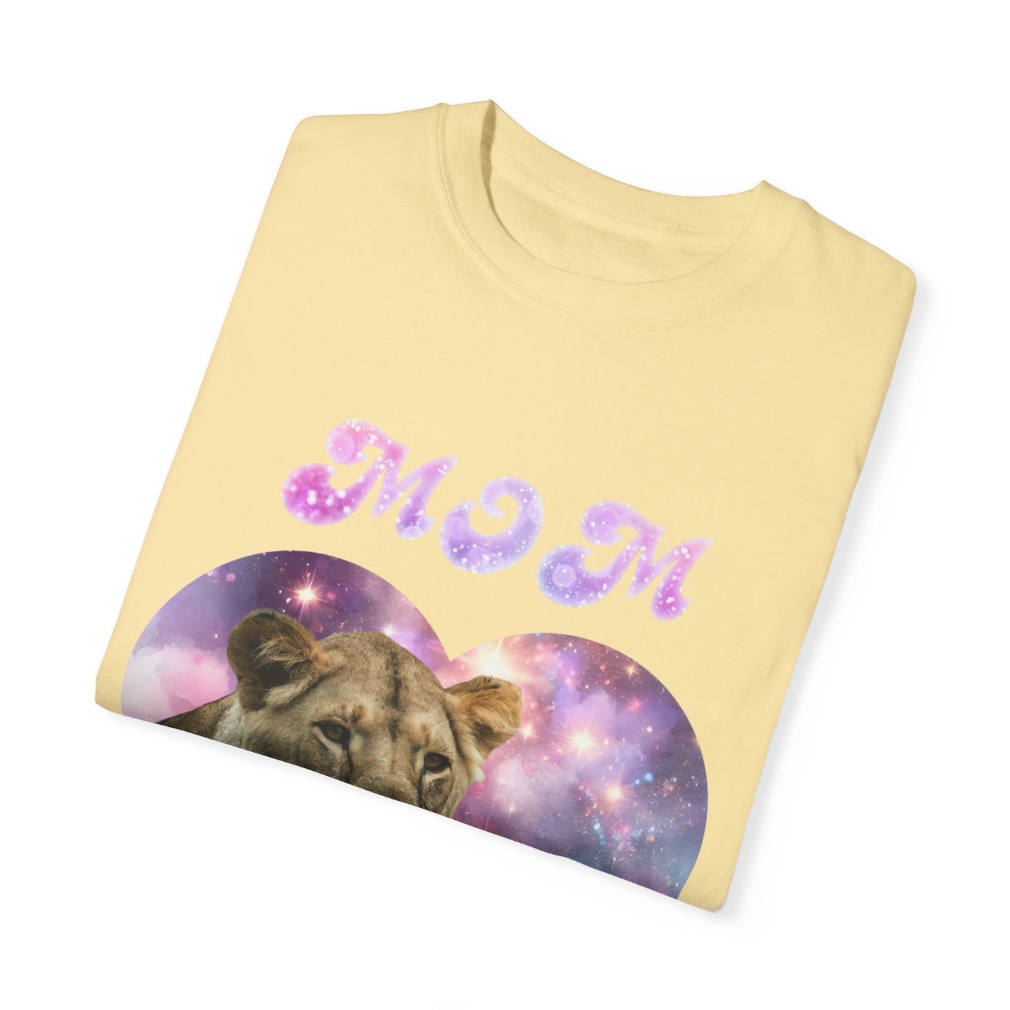 Folded yellow t-shirt featuring a lioness graphic against a heart-shaped galaxy backdrop, adorned with "MOM" in pink sparkly letters. Made from 100% ring-spun cotton, the Stylish Comfort with Unisex Comfort Colors 1717 Garment-Dye T-shirt - Heart of the Cosmos: Mom's Lioness Legacy offers a soft and stylish touch.