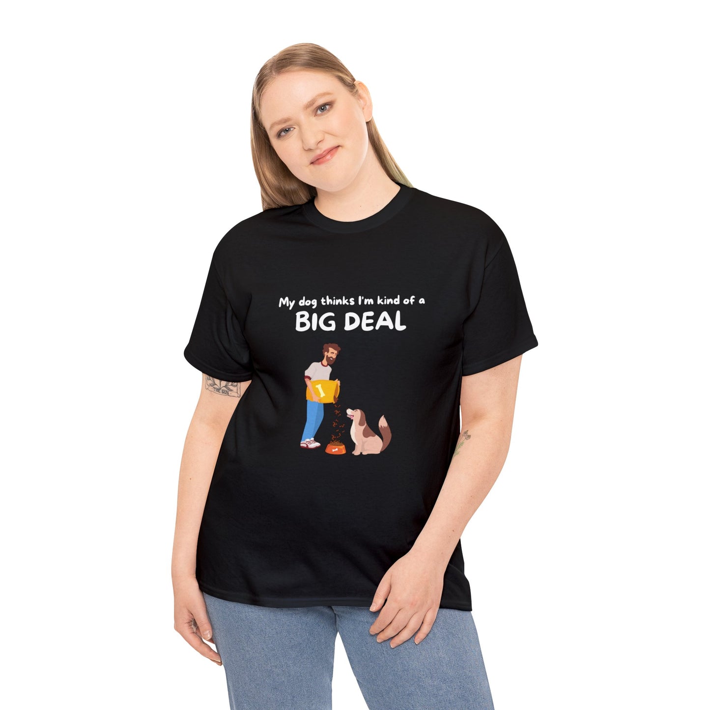 A dog lover sports a Unisex Heavy Cotton Tee - MY DOG THINKS IM A BIG DEAL, featuring the phrase "My dog thinks I’m kind of a big deal," complemented by an illustration of a person with their furry companion.