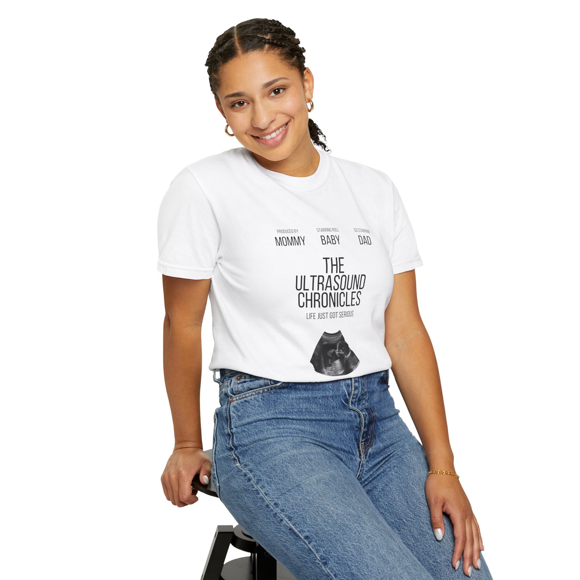 Woman in white Stylish Comfort with Unisex Comfort Colors 1717 Garment-Dye T-shirt with ultrasound image and text, "the ultrasound chronicles", smiling and seated on a stool at her baby shower.