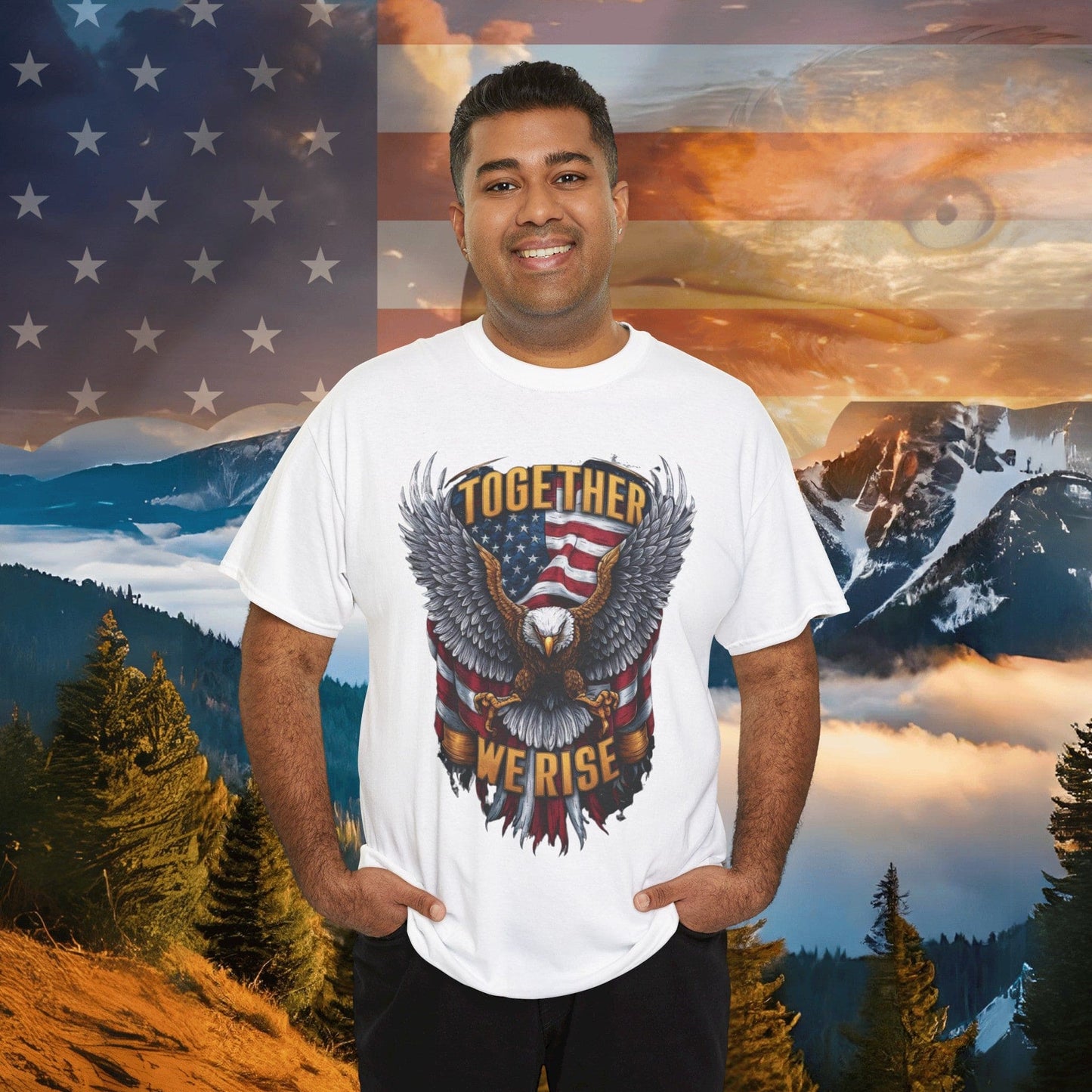 A person smiles, wearing a Unisex Heavy Cotton Tee - AMERICA - FLAG AND EAGLE - TOGETHER WE RISE shirt made from sustainably sourced cotton, set against a picturesque mountain and American flag backdrop. Capturing the essence of unity and freedom, this outfit effortlessly radiates American pride.