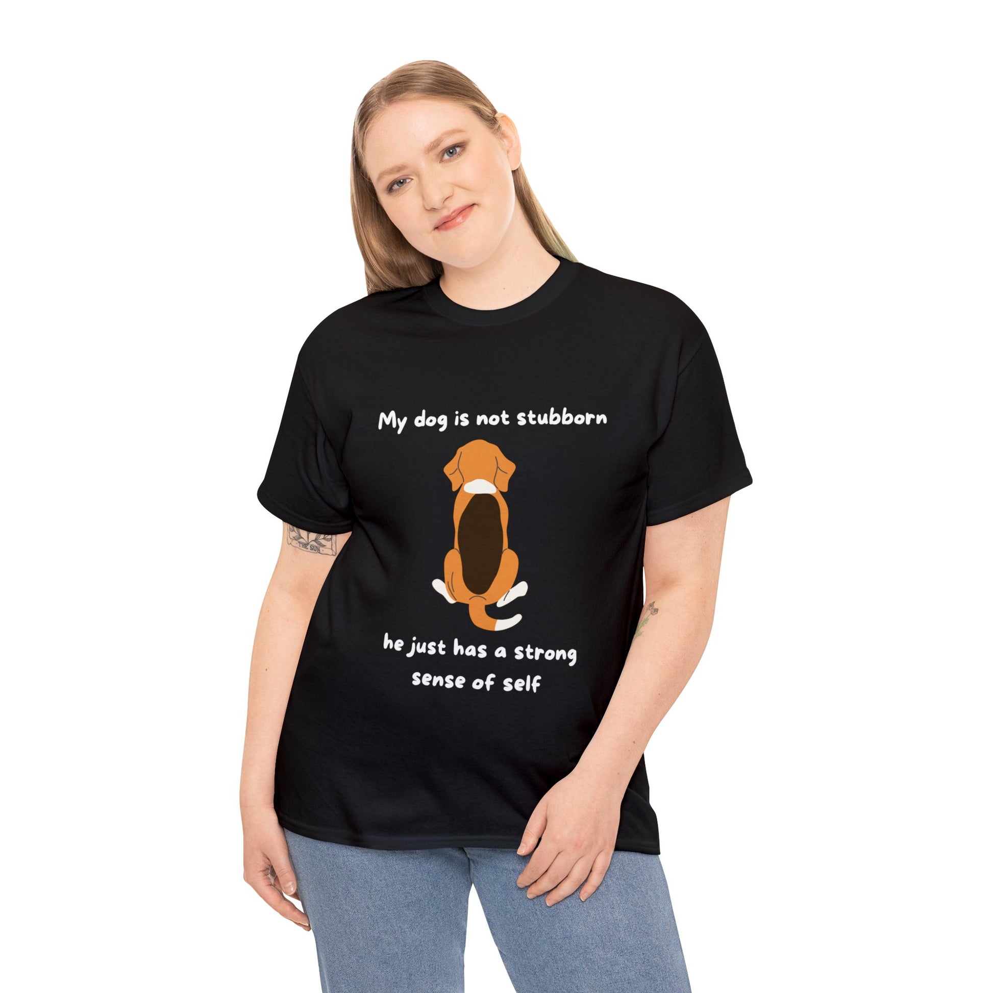 Someone wears the Unisex Heavy Cotton Tee - MY DOGS NOT STUBBORN- BEAGLE2, a black T-shirt with a dog illustration and the text: "My dog is not stubborn; he just has a strong sense of self." Made from 100% cotton, this classic fit tee merges style with sustainable production.