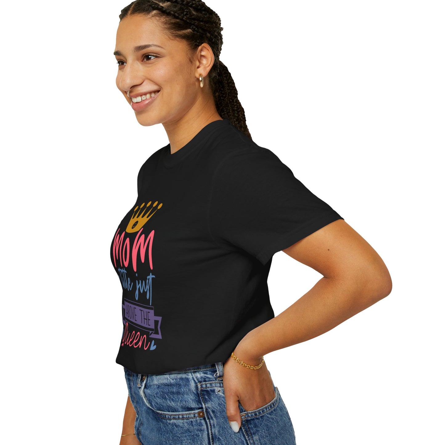 A person is smiling while wearing the Stylish Comfort Unisex Comfort Colors 1717 Garment-Dyed T-Shirt, featuring colorful text that reads "mom just a little above queen," perfectly paired with blue jeans.