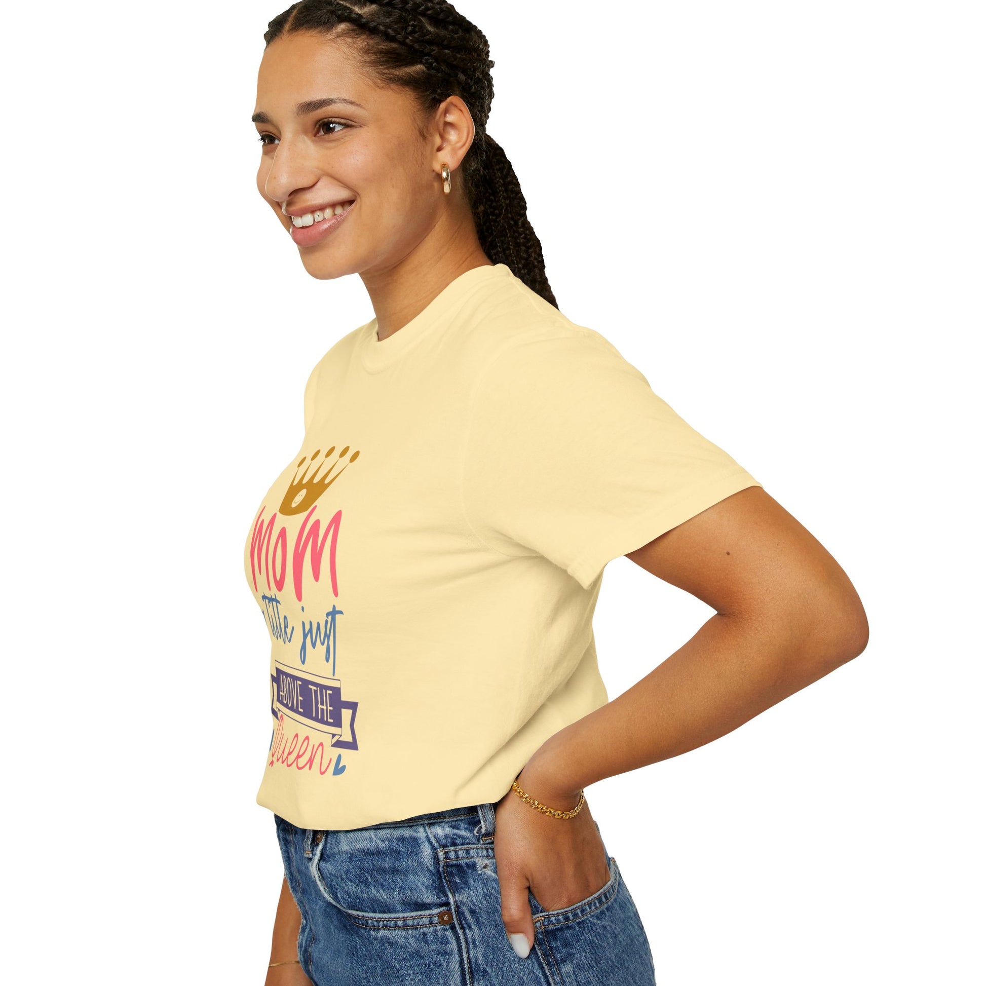 A woman wearing the Stylish Comfort with Unisex Comfort Colors 1717 Garment-Dyed T-Shirt in a vibrant yellow, showcasing a colorful "mom just a little above queen" design and crafted from soft ring-spun cotton, paired with blue jeans, smiles against a plain white background.