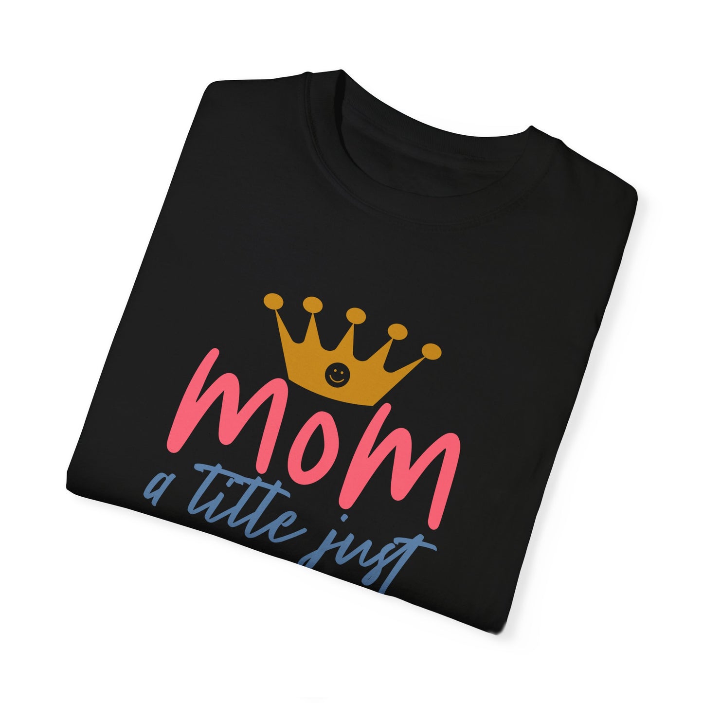 Experience style and comfort with the Unisex Comfort Colors 1717 Garment-Dyed T-Shirt in folded black, made from soft ring-spun cotton. It features a striking gold crown design complemented by the phrase "mom just a little above queen.