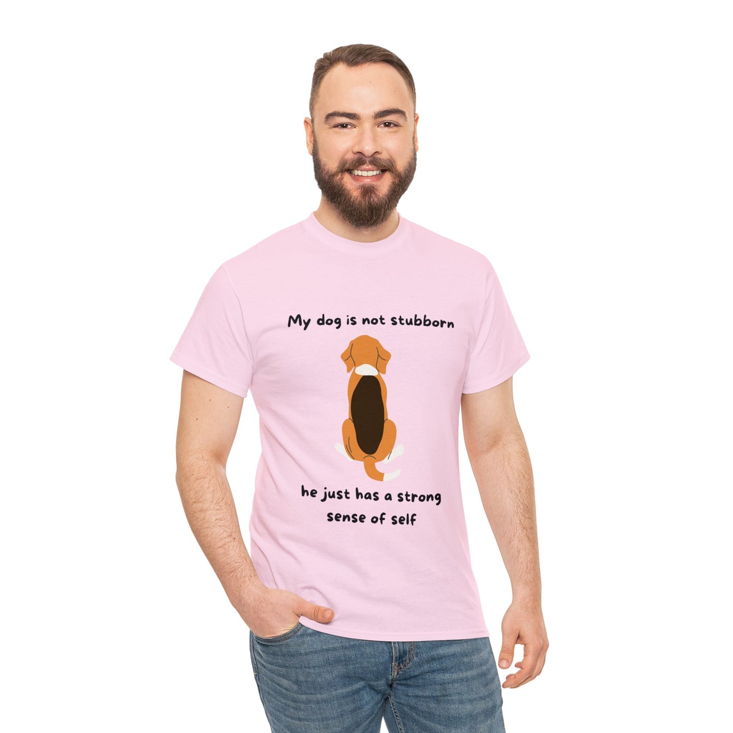 A man wearing the Unisex Heavy Cotton Tee - MY DOGS NOT STUBBORN- BEAGLE2, a classic fit pink t-shirt made from 100% cotton, features an illustration of a beagle and the text "My dog is not stubborn, he just has a strong sense of self.