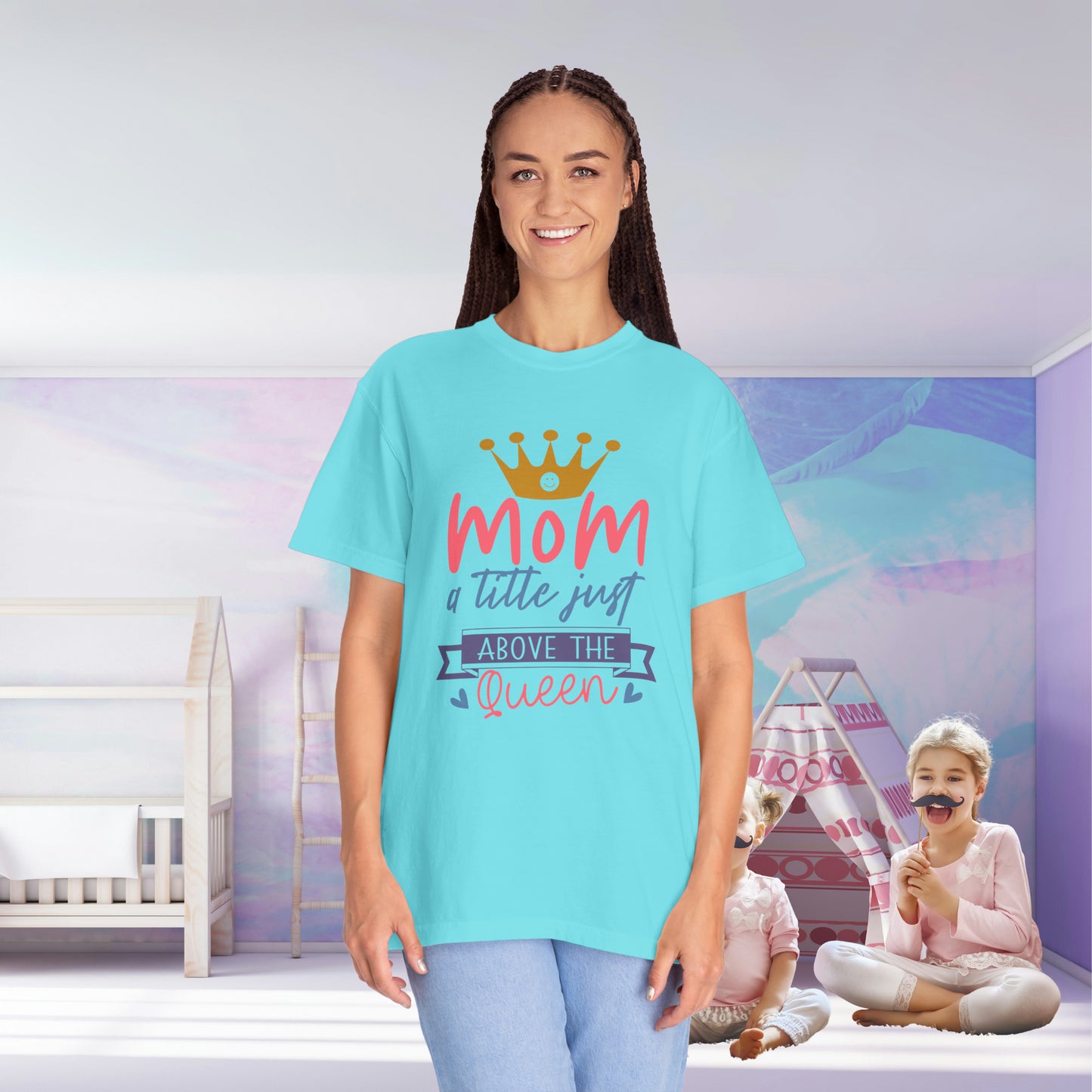 A person wearing a "Stylish Comfort with Unisex Comfort Colors 1717 Garment-Dyed T-Shirt - mom just a little above queen," crafted from soft ring-spun cotton, stands in a room with children sitting and playing on the floor.