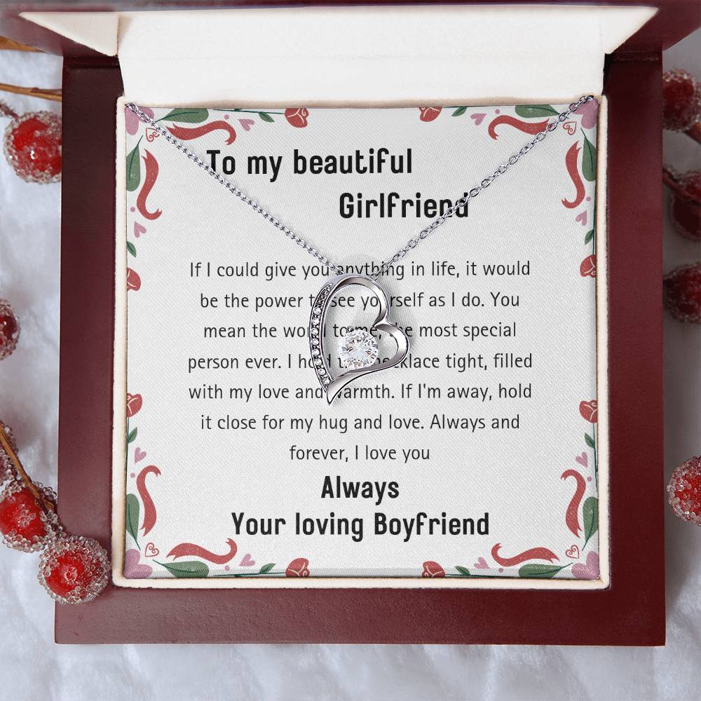 The 20240114_112056_0001 Forever Love Necklace, featuring a heart-shaped pendant with a gold finish and adorned with cubic zirconia, is showcased beautifully in an open box. It is accompanied by a printed romantic message for your girlfriend and surrounded by decorative red berries.