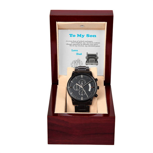 A Black Chronograph Watch + MC (NO ENGRAVING)- Trucking Father and Son is displayed inside an open wooden gift box. The box includes an insert with a printed message, "To My Son" along with the phrases "Love, Dad" and "In every turn of the hands." This heartfelt gift makes the perfect Father’s Day surprise, capturing a father's timeless love.