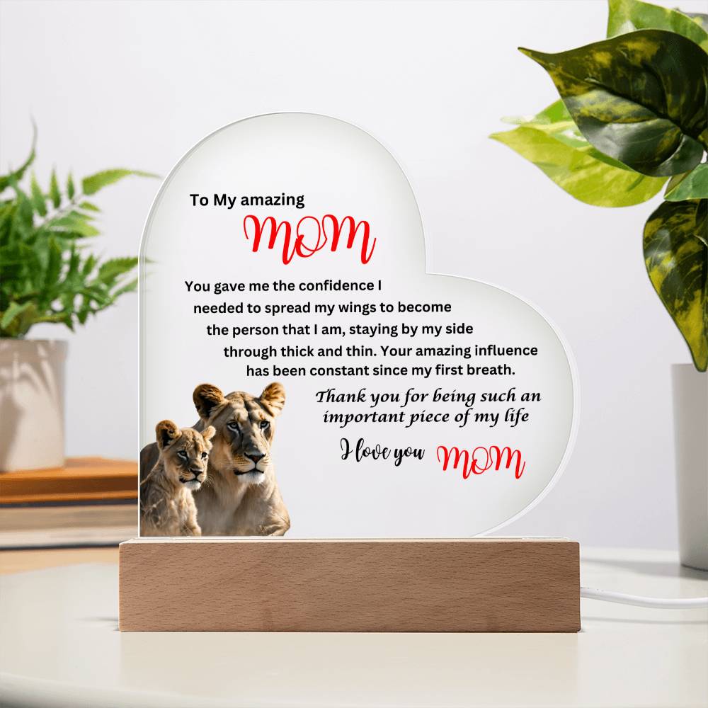 A "To my amazing mom lions acrylic heart plaque with wooden base" adorned with lions, perfect as a gift for mom.