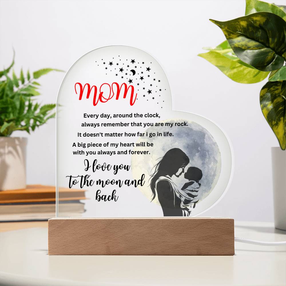 A gift with a picture of a woman and a baby on the "Mom, you are my rock, i love you to the moon" acrylic heart plaque with wooden base, symbolizing love.