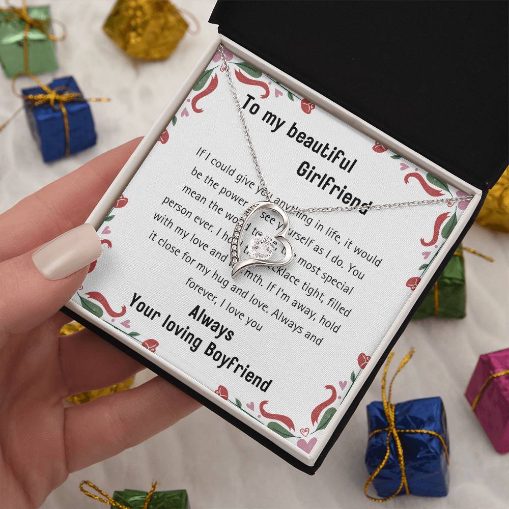 A 20240114_112056_0001 Forever Love Necklace, adorned with a white gold heart pendant, is beautifully presented in a box featuring a heartfelt message and displayed gently in hand. In the background, gift boxes embellished with cubic zirconia sparkle elegantly.