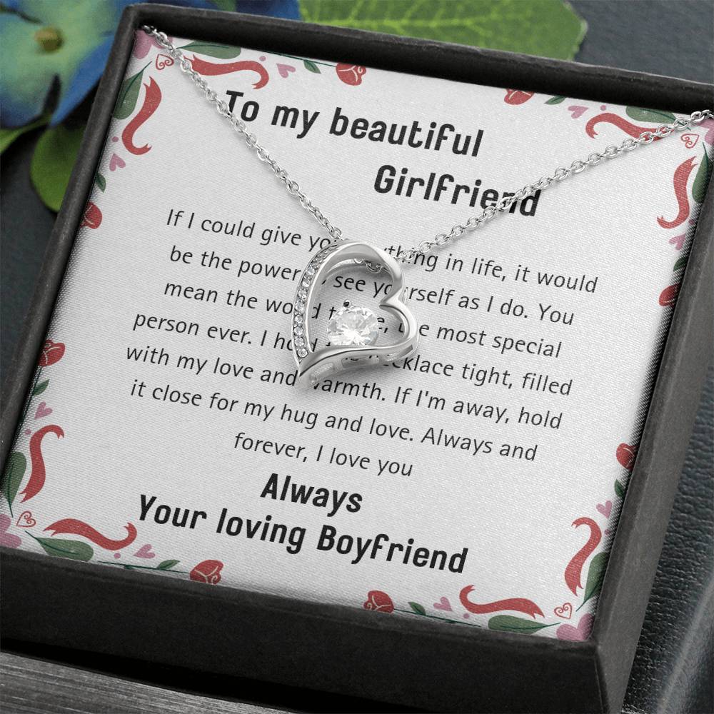 The 20240114_112056_0001 Forever Love Necklace showcases a heart-shaped pendant adorned with a sparkling cubic zirconia center and is elegantly packaged in a box with a heartfelt message for your girlfriend on the background card.