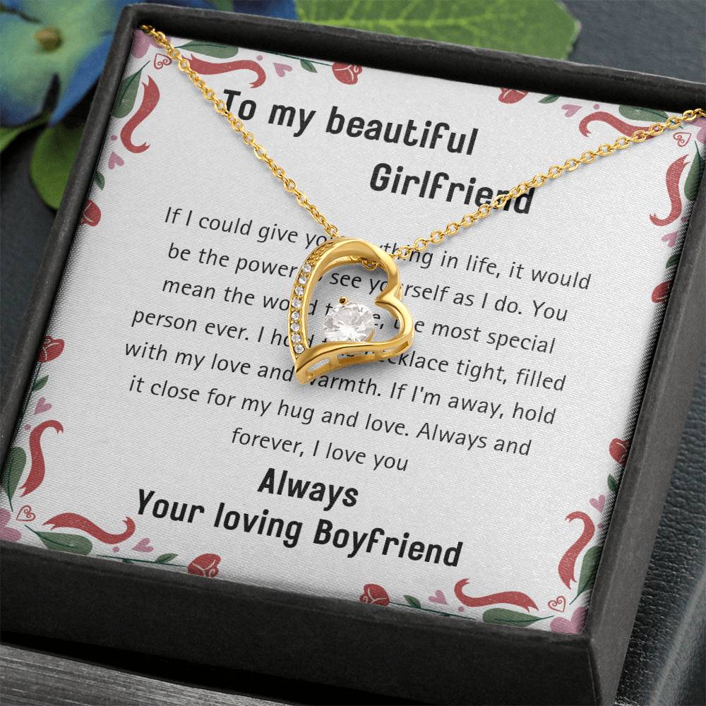 The 20240114_112056_0001 Forever Love Necklace, featuring a gold heart-shaped pendant embellished with a sparkling cubic zirconia, is elegantly placed on a white note bearing a romantic message and presented in a sophisticated black box.